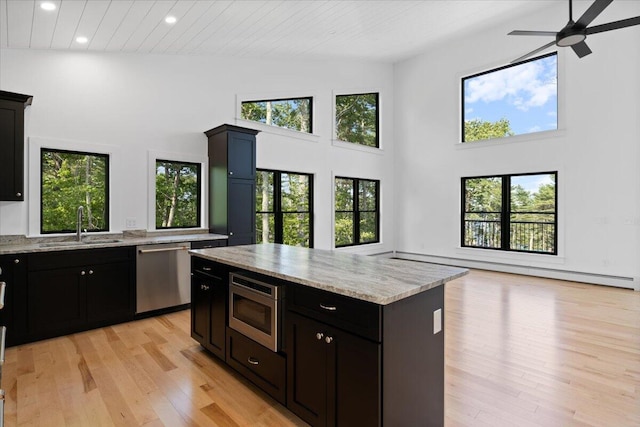 676 Sebago Rd, Sebago, ME 04029 - kitchen featuring a ceiling fan, appliances with stainless steel finishes, light wood-type flooring, a sink, and a high ceiling