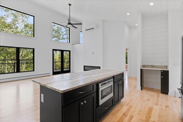 676 Sebago Rd, Sebago, ME 04029 - kitchen with a towering ceiling, open floor plan, recessed lighting, a baseboard heating unit, and dark cabinetry