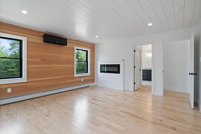 676 Sebago Rd, Sebago, ME 04029 - unfurnished living room with wooden walls, a wall unit AC, a healthy amount of sunlight, and a baseboard radiator
