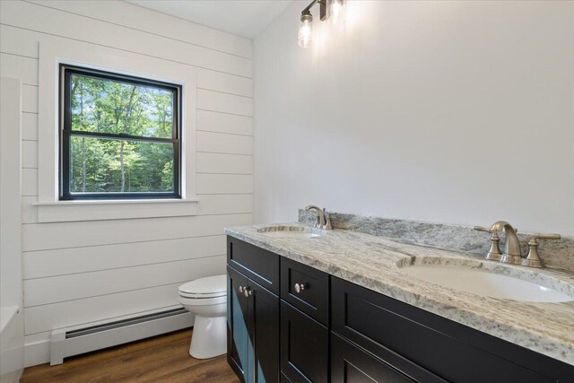 676 Sebago Rd, Sebago, ME 04029 - bathroom with double vanity, toilet, a baseboard heating unit, and a sink