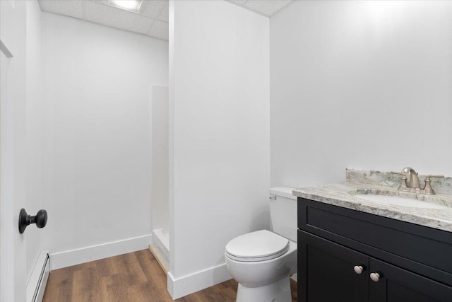 676 Sebago Rd, Sebago, ME 04029 - full bath with wood finished floors, a walk in shower, vanity, a baseboard heating unit, and toilet