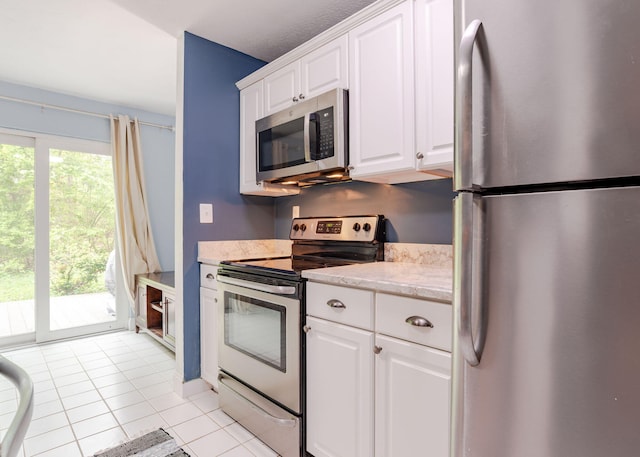 135 Portland Ave Unit 803, Old Orchard Beach, ME 04064 - kitchen with appliances with stainless steel finishes, light tile patterned floors, and white cabinetry