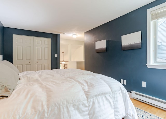 135 Portland Ave Unit 803, Old Orchard Beach, ME 04064 - bedroom with a baseboard heating unit, wood finished floors, a closet, and baseboards