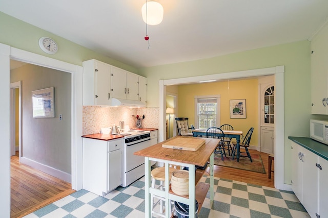 8 Park St, Camden, ME 04843 - kitchen with white appliances, white cabinetry, under cabinet range hood, backsplash, and light wood-style flooring