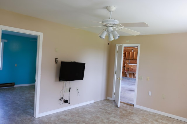 unfurnished living room featuring a ceiling fan, baseboard heating, and baseboards