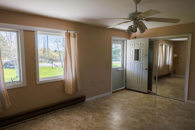 unfurnished room with a baseboard radiator, healthy amount of natural light, and baseboards