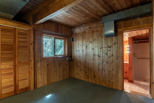 interior space featuring wood walls, wood ceiling, and carpet flooring