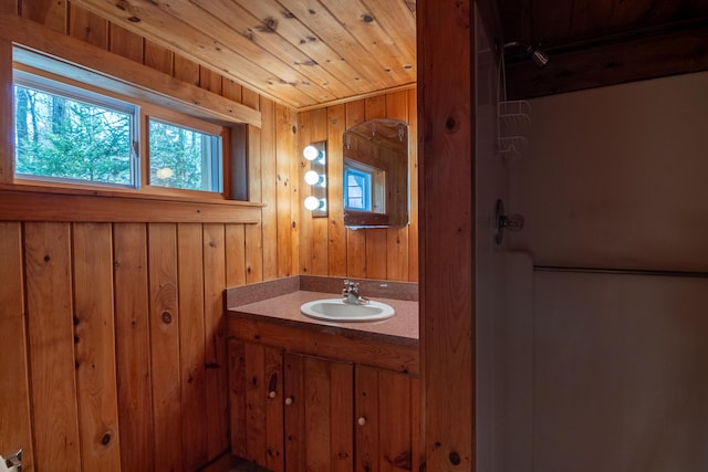 bathroom featuring wooden ceiling, vanity, and wood walls