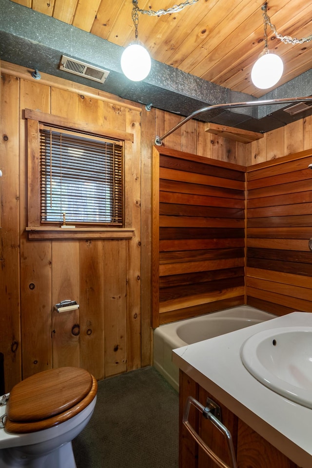 bathroom with visible vents, vanity, toilet, wooden walls, and wooden ceiling