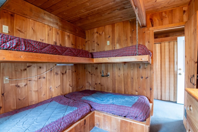 bedroom featuring carpet flooring, wooden walls, and wooden ceiling