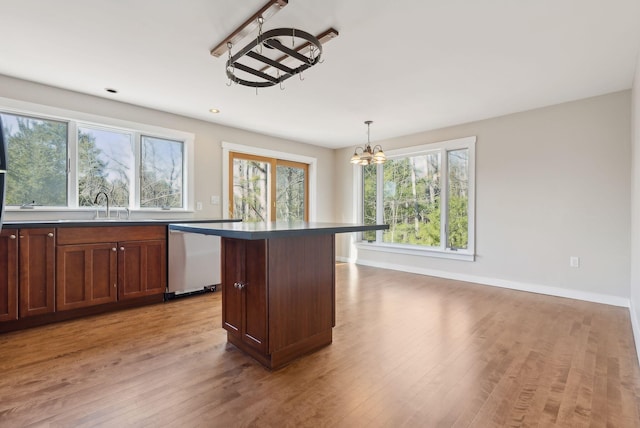 27 Rein Rd, Saint George, ME 04859 - kitchen featuring dark countertops, dishwasher, baseboards, a chandelier, and light wood-style floors