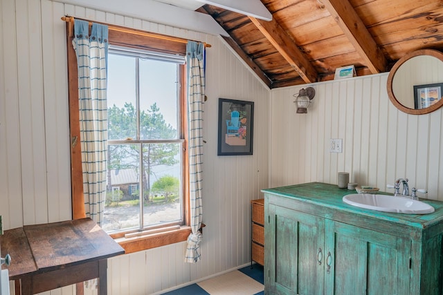 bathroom featuring vanity, wood ceiling, and wood walls