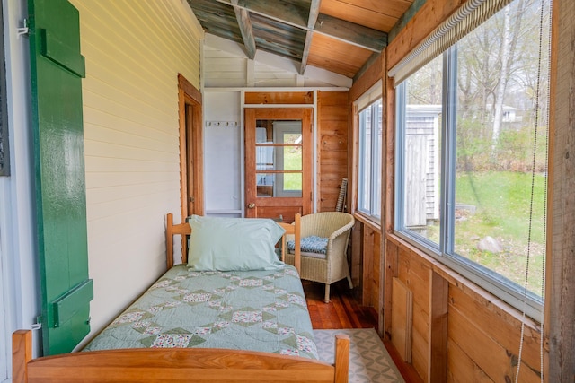 sunroom / solarium featuring wood walls, vaulted ceiling, and wood finished floors