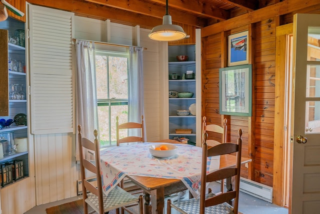 dining room with wooden walls, beamed ceiling, a baseboard heating unit, and wood ceiling