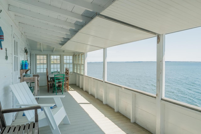 sunroom featuring a water view