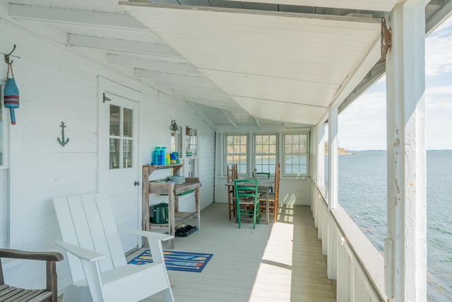 sunroom / solarium with a water view and vaulted ceiling