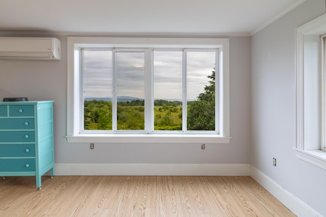 361 Sedgwick Ridge Rd, Sedgwick, ME 04676 - spare room featuring a wall mounted AC, light wood-style floors, and ornamental molding