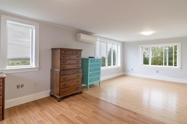361 Sedgwick Ridge Rd, Sedgwick, ME 04676 - bedroom featuring an AC wall unit, multiple windows, and light wood-style flooring