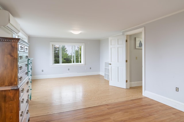361 Sedgwick Ridge Rd, Sedgwick, ME 04676 - unfurnished room featuring a wall mounted AC, light wood-style floors, and ornamental molding