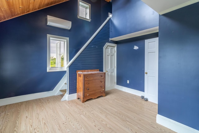 361 Sedgwick Ridge Rd, Sedgwick, ME 04676 - unfurnished living room with a wall mounted air conditioner, high vaulted ceiling, and wood finished floors