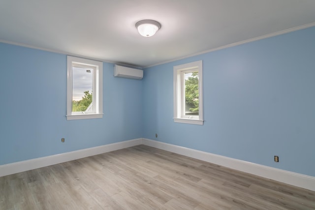 361 Sedgwick Ridge Rd, Sedgwick, ME 04676 - unfurnished room with a wall mounted air conditioner, healthy amount of natural light, light wood finished floors, and crown molding