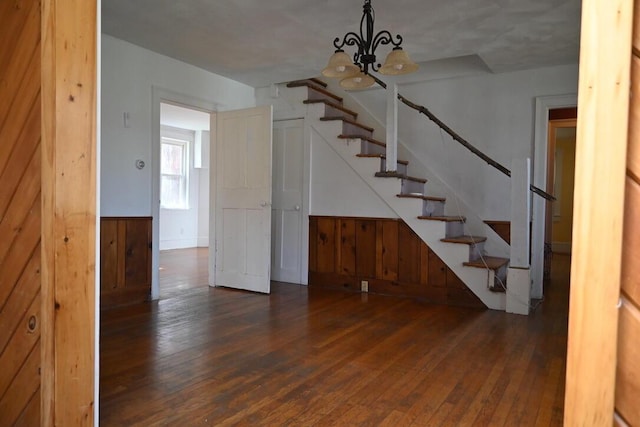 104 Northern Ave, Gardiner, ME 04345 - staircase featuring wood-type flooring, wooden walls, a wainscoted wall, and a notable chandelier