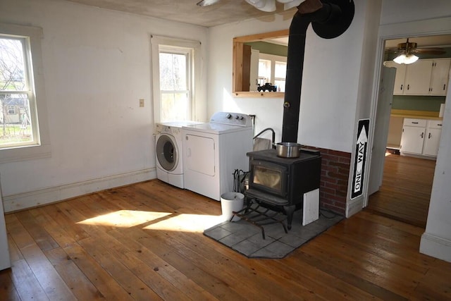 104 Northern Ave, Gardiner, ME 04345 - clothes washing area featuring laundry area, a ceiling fan, independent washer and dryer, a wood stove, and hardwood / wood-style flooring