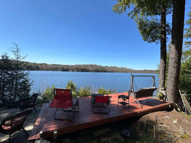 dock area featuring a deck with water view and a forest view