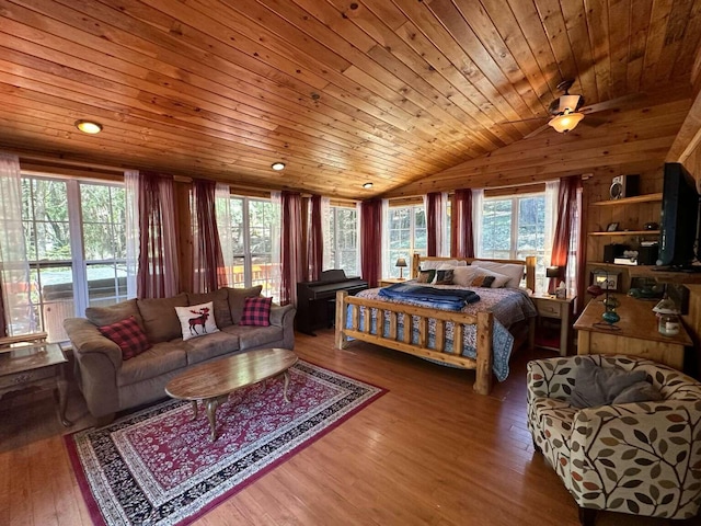 bedroom with wood ceiling, vaulted ceiling, wood walls, and wood finished floors