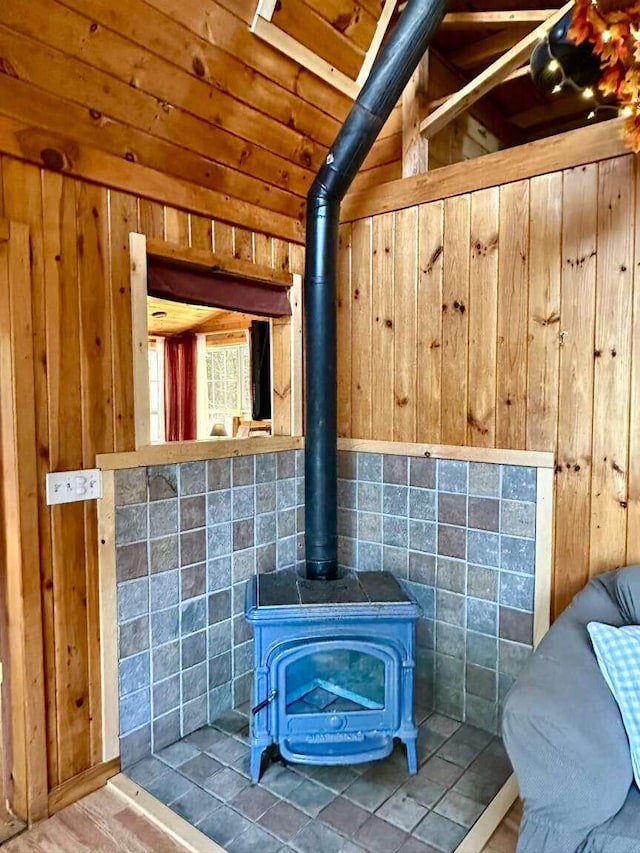 interior details featuring a wood stove and wood walls