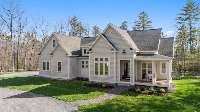 view of front of property featuring roof with shingles, a front lawn, and a trampoline