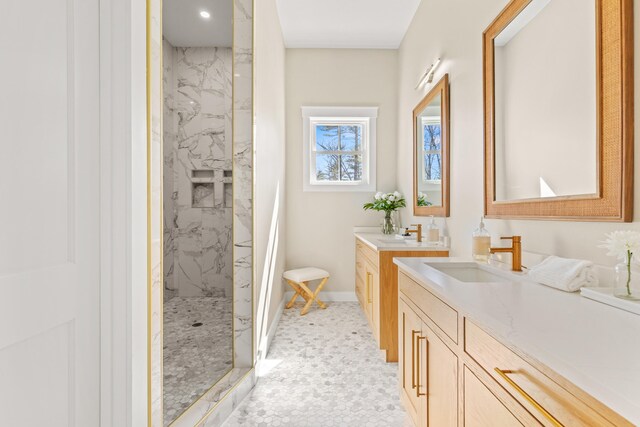 bathroom featuring a marble finish shower, vanity, baseboards, and recessed lighting