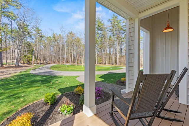 wooden deck featuring a lawn