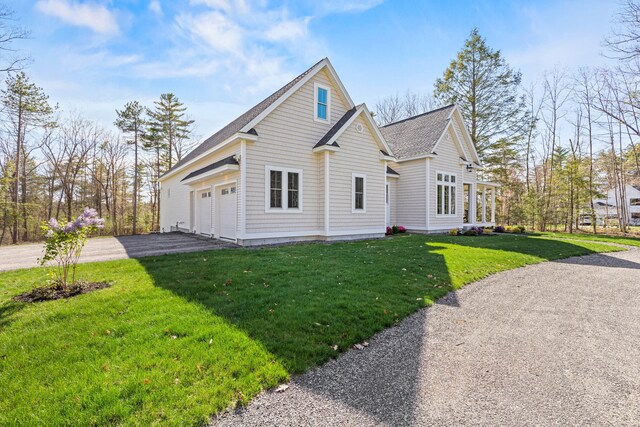 view of front of house featuring driveway, a front lawn, roof with shingles, and a garage