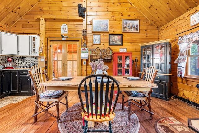 291 River Rd, Milo, ME 04463 - dining space featuring french doors, vaulted ceiling, wooden ceiling, wooden walls, and light wood-style floors