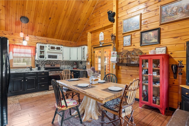 291 River Rd, Milo, ME 04463 - dining area with wood ceiling, wood walls, light wood-style flooring, and high vaulted ceiling