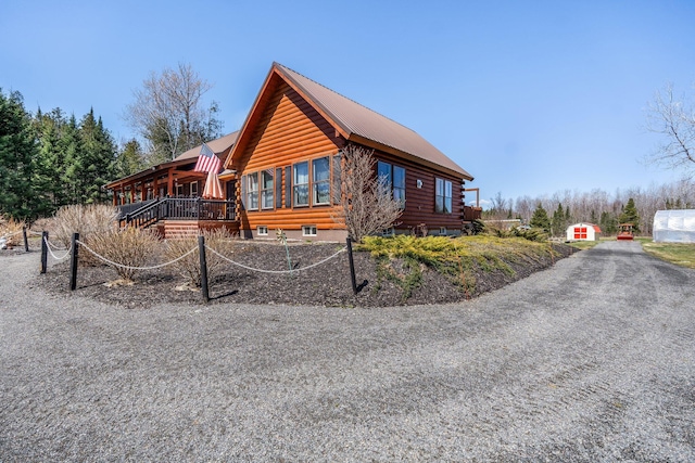 291 River Rd, Milo, ME 04463 - view of home's exterior with log siding, a wooden deck, and metal roof