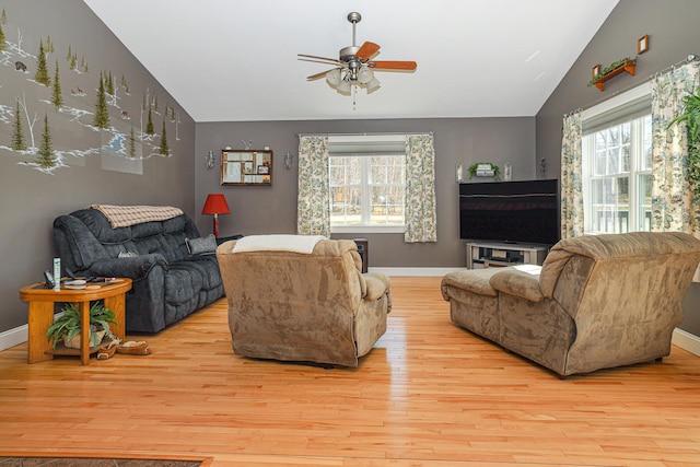living area with a ceiling fan, baseboards, vaulted ceiling, and wood finished floors