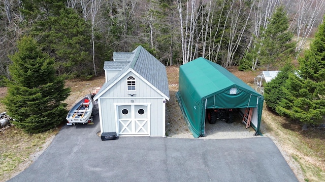 garage featuring driveway and a detached carport