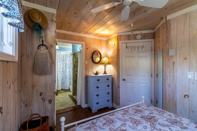 bedroom featuring connected bathroom, wood ceiling, wood walls, and dark wood-style floors