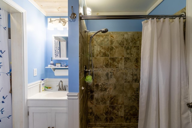 full bathroom featuring tiled shower, vanity, and crown molding