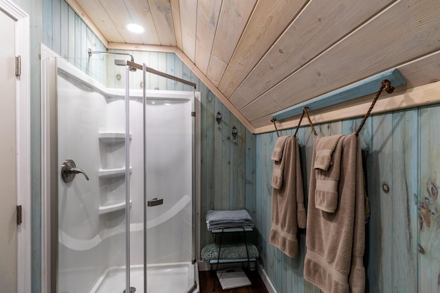 bathroom featuring lofted ceiling, wood finished floors, a stall shower, wooden walls, and wood ceiling