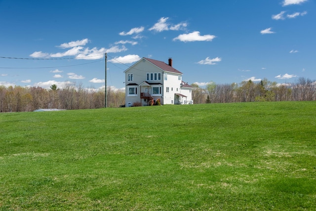 back of property with a lawn and a chimney