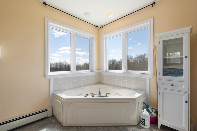 bathroom with tile patterned floors, a baseboard heating unit, and a bath