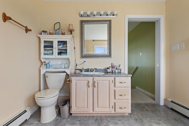 bathroom featuring baseboards, baseboard heating, toilet, and vanity