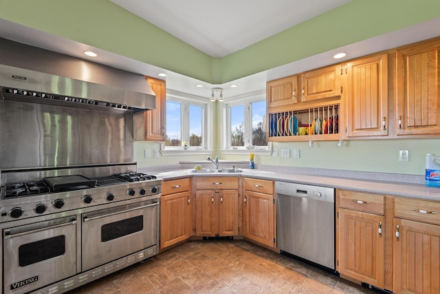 kitchen with wall chimney range hood, a sink, light countertops, stainless steel appliances, and recessed lighting
