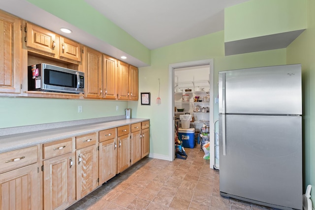 kitchen featuring light countertops, recessed lighting, light brown cabinetry, and appliances with stainless steel finishes