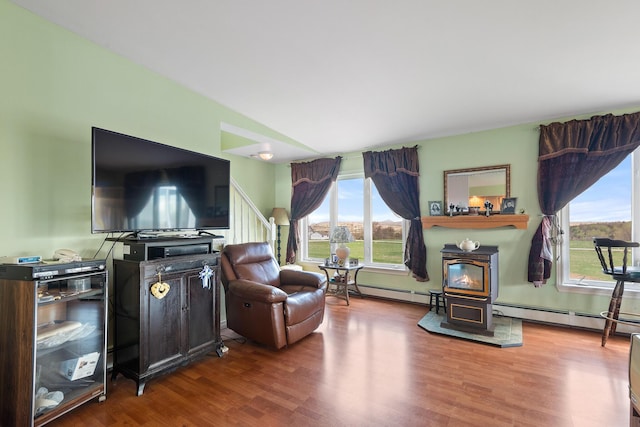 living room with baseboard heating, a wood stove, and wood finished floors