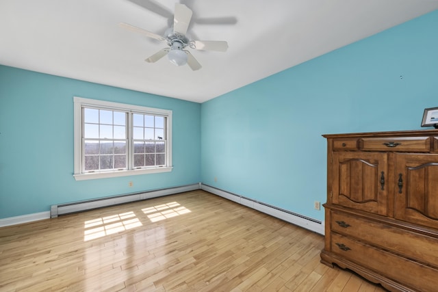 unfurnished bedroom with light wood-style floors, baseboards, a baseboard radiator, and ceiling fan