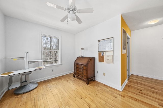 interior space featuring baseboards, a ceiling fan, and wood-type flooring